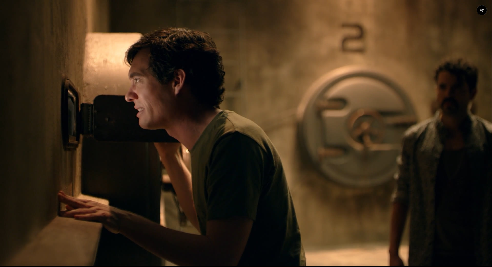 Inside the Crunch Time bunker set: a character at the peephole slot in the concrete wall, the numbered vault door behind him.