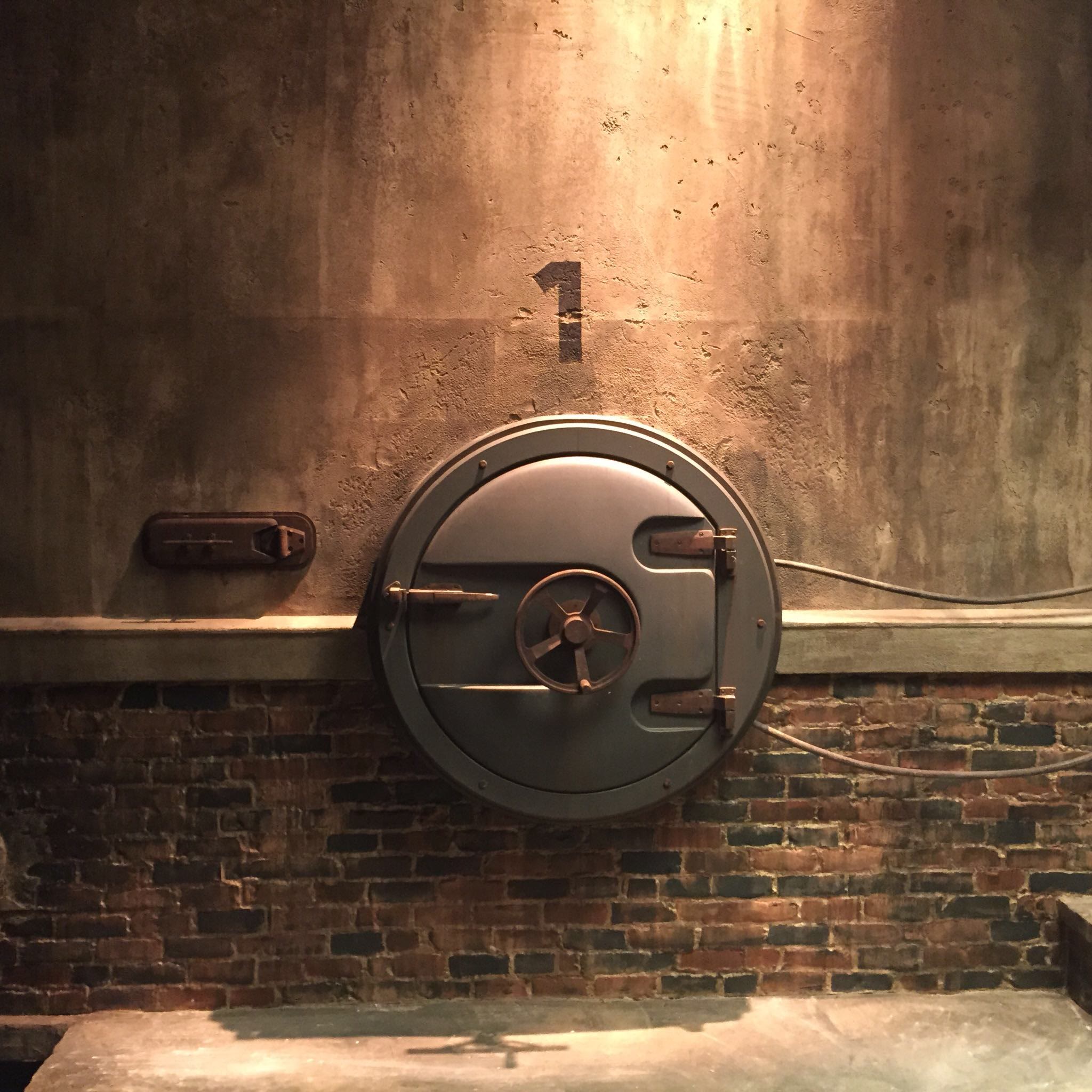 Detail of hatch one on the finished Brainframe set, with its intercom panel alongside and scenic concrete-over-brick treatment.